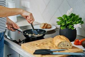 Frau Kochen Omelett , verwenden Induktion Herd und braten schwenken foto