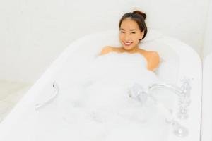 Porträt schöne junge asiatische Frau nimmt eine Badewanne im Badezimmer foto