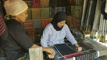 Frau Weberei Seide Stoff und kain Songket beim das Markt im Lombok, Indonesien foto