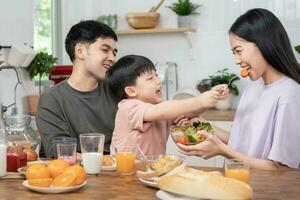 Familie Zeit, Frühstück, Aktivitäten zusammen während das Feiertage. Eltern und Kinder sind haben ein Mahlzeit zusammen während das Feiertage. Neu Zuhause zum Familie auf Morgen, genießen, Wochenende, vakant Zeit foto