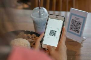 frau verwendet smartphone, um qr-code zu scannen, um im caférestaurant mit einer digitalen zahlung ohne bargeld zu bezahlen. Menü wählen und bestellen Rabatt kumulieren. E-Geldbörse, Technologie, online bezahlen, Kreditkarte, Bank-App. foto