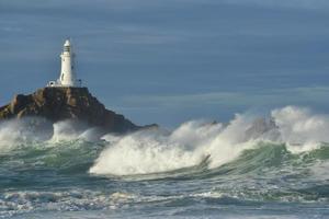 Corbiere Lighthouse Jersey UK Herbstwellen mit einem warmen Meeresmorgen Küstenstrukturbild foto