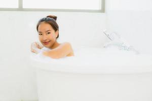 Porträt schöne junge asiatische Frau nimmt eine Badewanne im Badezimmer foto