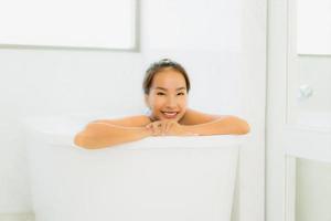 Porträt schöne junge asiatische Frau nimmt eine Badewanne im Badezimmer foto
