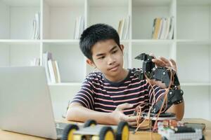 asiatisch Teenager tun Roboter Projekt im Wissenschaft Klassenzimmer. Technologie von Robotik Programmierung und Stengel Bildung Konzept. foto