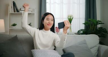 asiatisch Frau spielen ein Spiel auf Smartphone foto