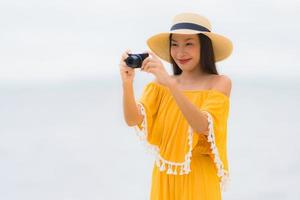 Porträt schöne asiatische Frau Hut mit Lächeln glücklich Freizeit in ein Foto am Strand und Meer im Urlaub machen