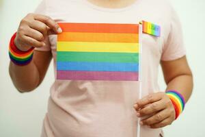 asiatische frau mit regenbogenflagge, lgbt-symbolrechten und geschlechtergleichstellung, lgbt-stolzmonat im juni. foto