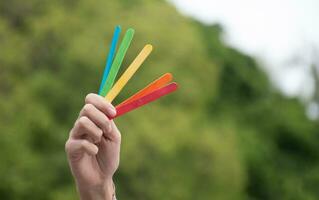 Eis Stöcke im Regenbogen Farben halten im Hände von asiatisch Junge, Sanft und selektiv Fokus, Konzept zum Berufung aus alle Menschen zu Unterstützung lgbt Veranstaltungen und Kampagnen um das Welt. foto