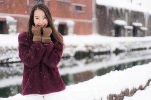 schöne junge asiatische frau lächeln und glücklich mit reisereise in otaru kanal hokkaido japan foto