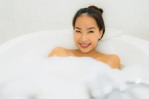 Porträt schöne junge asiatische Frau nimmt eine Badewanne im Badezimmer foto