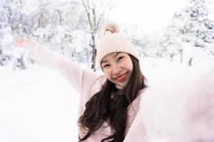 Porträt junge schöne asiatische Frau lächelt glückliche Reise und genießt mit Schnee Wintersaison foto