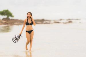 Porträt schöne junge asiatische Frau trägt Bikini am Strand Meer Ozean foto