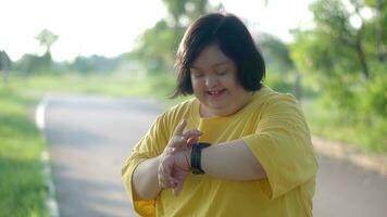 asiatisch Mädchen mit Nieder Syndrom Aufpassen das Uhr während ausüben beim das Park. foto