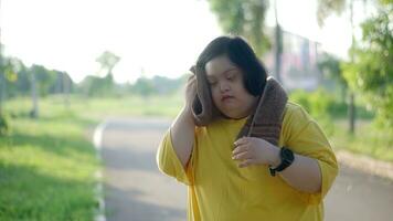 Aufpassen das Uhr während ausüben beim das Park ist ein asiatisch Mädchen mit Nieder Syndrom. foto