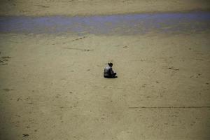 Frau sitzt am Strand foto