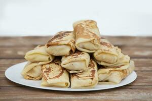 Pfannkuchen gerollt in ein Tube auf ein Platte. Pfannkuchen mit Füllung zum masleniza. foto