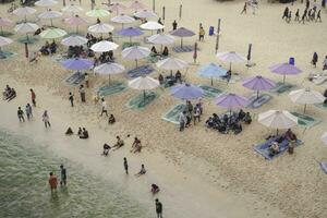 Antenne Drohne Aussicht von Urlaub im Ndrini Strand, Yogyakarta, Indonesien mit Ozean, Strand, Regenschirme, und Personen. foto