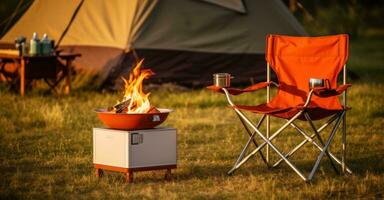 Orange Camping Stuhl und ein Orange Lagerfeuer beim das Lager foto