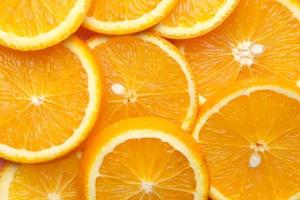 Nahaufnahme einer Orangenscheibe auf farbigem Hintergrund