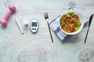Diabetiker-Messgeräte und gesundes Essen auf dem Tisch foto