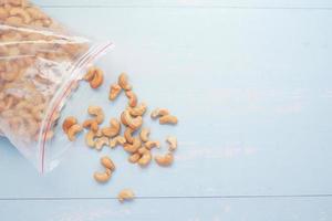 Cashewnuss verschüttet aus einer Plastiktüte auf dem Tisch foto