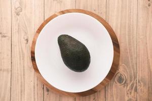 Draufsicht der Avocadoscheibe auf einem Teller auf Holztisch on