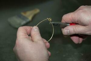 Schmuck Meister beim Arbeit auf das Herstellung von ein Gold Ring. Schmuck Fabrik. foto