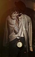 retro fotografieren von ein passen mit ein Krawatte und ein Uhr auf ein Kette gegen ein Hintergrund von Risse und Kratzer. das Konzept von ein unwiderruflich Weg Zeit. foto