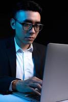 Porträt eines asiatischen männlichen Programmierers, der nachts arbeitet
