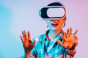 Junge Asiatin trägt eine VR-Brille, um Augmented-Reality-Technologie zu erleben foto
