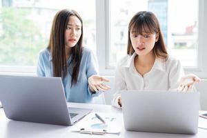 Asiatische Geschäftsfrau und ihre Kollegen streiten miteinander über den Arbeitsplan