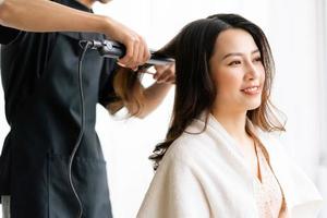 asiatische Frau mit glücklichem Ausdruck beim Friseur im Salon foto