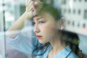 Asiatische Geschäftsfrau fühlt sich aufgrund des Arbeitsdrucks müde foto