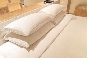 weiße Kissendekoration auf dem Bett im Schlafzimmer des Luxushotelresorts foto