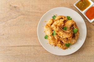 gebratener Fisch mit Knoblauch auf Teller foto