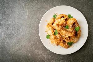 gebratener Fisch mit Knoblauch auf Teller foto