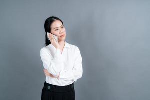 asiatische Frau, die Handy benutzt, um Geschäft zu sprechen foto