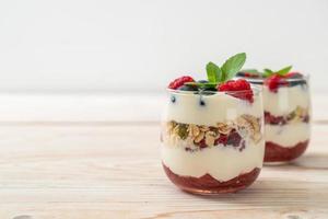 hausgemachte Himbeeren und Heidelbeeren mit Joghurt und Müsli - gesunder Ernährungsstil foto