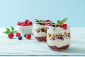 hausgemachte Himbeeren und Heidelbeeren mit Joghurt und Müsli - gesunder Ernährungsstil foto