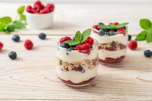 hausgemachte Himbeeren und Heidelbeeren mit Joghurt und Müsli - gesunder Ernährungsstil foto