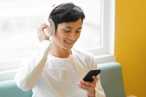 asiatischer Mann sitzt und genießt Musik foto