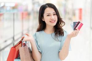 junges Mädchen, das eine Kreditkarte im Einkaufszentrum hält