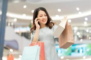 junges Mädchen kauft und telefoniert im Einkaufszentrum foto