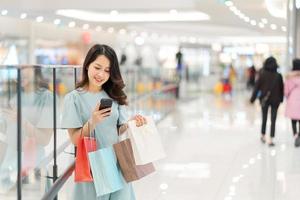 junges Mädchen kauft und telefoniert im Einkaufszentrum foto
