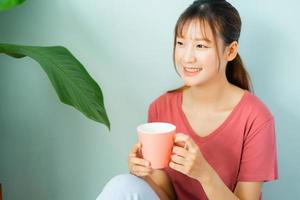 junge asiatische frau trinkt morgens kaffee