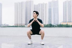 junger asiatischer Mann, der im Park trainiert foto