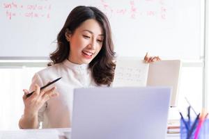 asiatische Lehrerin, die zu Hause online unterrichtet foto