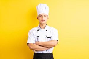 Bild des asiatischen männlichen Kochs auf gelbem Hintergrund foto