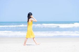 junge asiatische frau, die den sommerurlaub am strand genießt foto